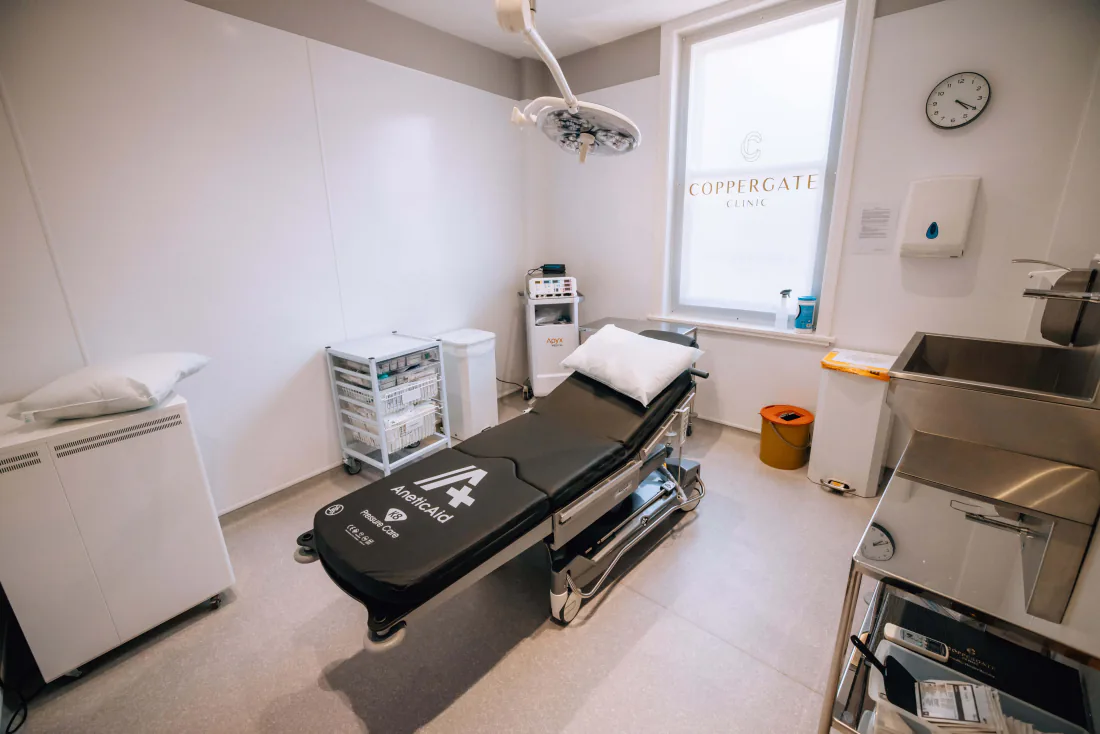 The procedure room at the clinic, the couch under the operating light.