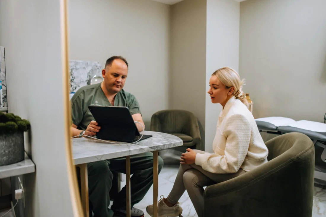Mr West going through a question with a patient at the consultation table.