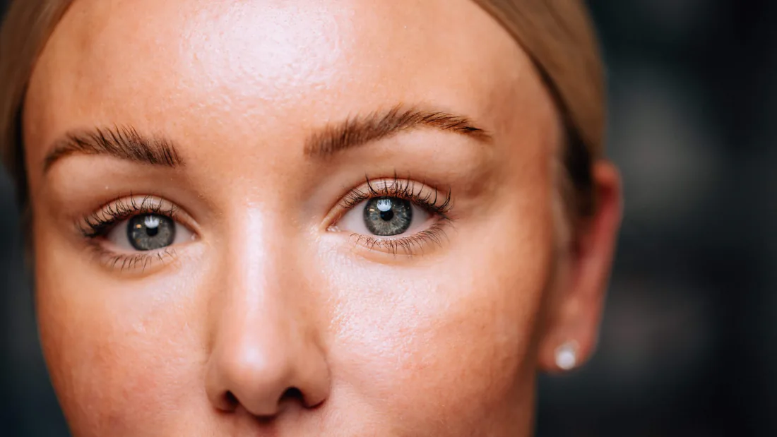 Close-up of a woman's eye, eyelid and brow.